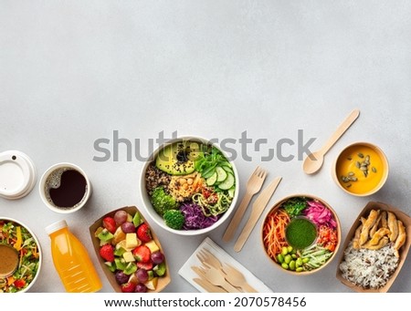 Healthy take away food and drinks in disposable eco friendly paper containers on gray background, top view. Fresh salad, soup, poke bowl, buddha bowl, fruits, coffee and juice. Royalty-Free Stock Photo #2070578456