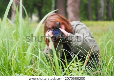 Outdoor nature photography. Young girl taking picture in nature, animal photographer