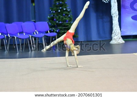 The girl performs a mandatory program in rhythmic gymnastics 