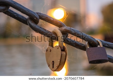 Rusty lovers locks on a chain on a bridge, lovers locks on a bridge chain