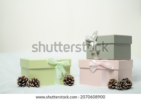 Pastel pink, green and gray gift boxes and Woody seed cones  , white background.Selective focus.