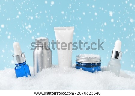 Winter skin care. Beauty products in a snowdrift, falling snow. Royalty-Free Stock Photo #2070623540