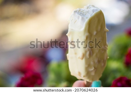 Young woman hand holding ice cream with white chocolate glaze
