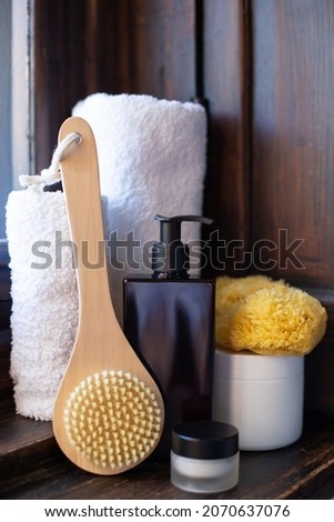 SPA set. Body care cosmetics and spa supplies stand on a wooden windowsill. Natural cosmetics concept. Vertical photo.