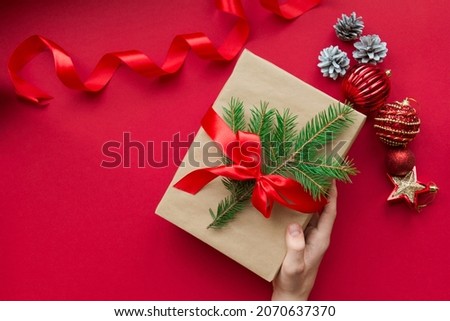 Christmas gift in hand. Red background. holiday. New Year