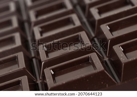 Close up a chocolate bar background. Chocolate bar cubes macro.