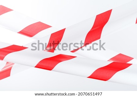 The tape is red and white for fencing danger on a white background. Tapes for warning and highlighting of danger