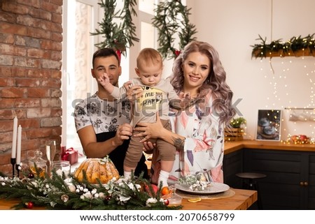 family in love on kitchen near nicely decorated Christmas tree, enjoying the Christmas magic.