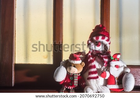 Christmas, concept with teddy bears sitting in a window and hugging each other, copy space left