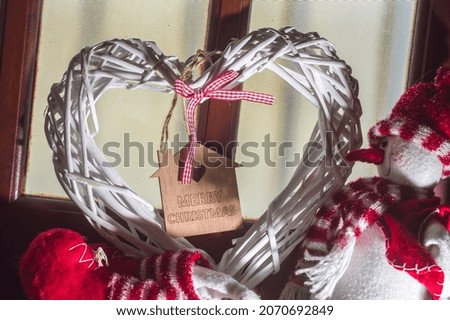Christmas concept with snowman and heart, inside the square of the heart is written: merry christmas