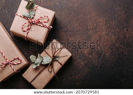 Minimalistic Christmas presents flat lay composition on dark concrete background. Christmas and New Year elegant gift boxes top view with free space for text template