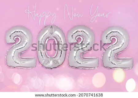 Happy New Year text. Balloon Bunting for celebration of New Year 2022 made from Silver Number Balloons. Holiday Party Decoration or postcard concept with top view and copy space.
