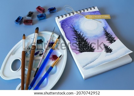 Christmas watercolor. Christmas painting. Winter sketches with watercolor paints. Top view of drawing, set of watercolor paints, brushes and palette 