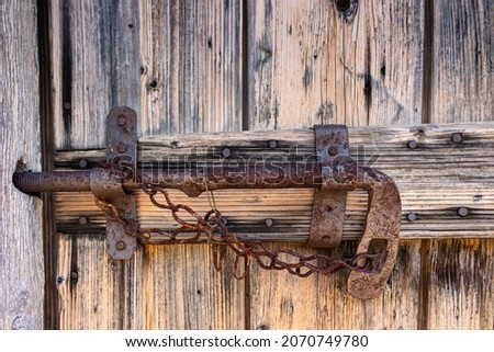 Close-up of a metal old fashioned latch on an old wooden door