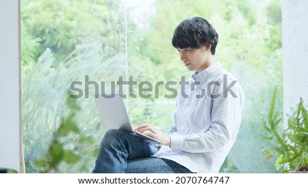 Asian young man working with a computer Royalty-Free Stock Photo #2070764747