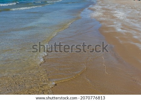 Waves roll on the sand on the beach