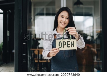 woman with smile turning a sign from closed to open. sme concept