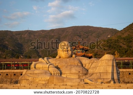 The giant Buddha statue at the foot of the mountain is located in the famous scenic spot Boa National Forest Park in Changping District, Beijing, China.