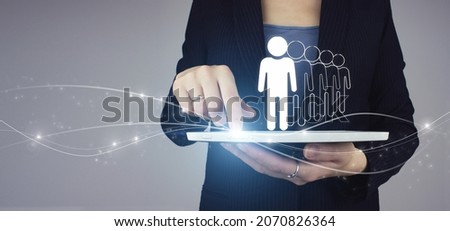 Recruitment Employment Headhunting Concept. White tablet in businesswoman hand with digital hologram Human, Leader icon sign on grey background. Business communication concept. Marketing. Teamwork.