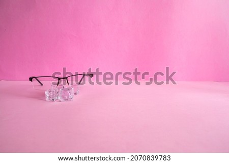 Product Presentation Minimalist Concept idea. glasses and ice cubes on pink paper background.