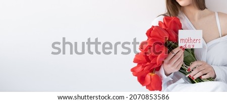Flowers for Mother's Day. Girl with tulips on a white background. Happy mother's day. Banner. Place for text
