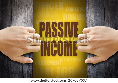 Hand opening a wooden door and found the "PASSIVE INCOME" word in the middle of many different words on yellow background.
