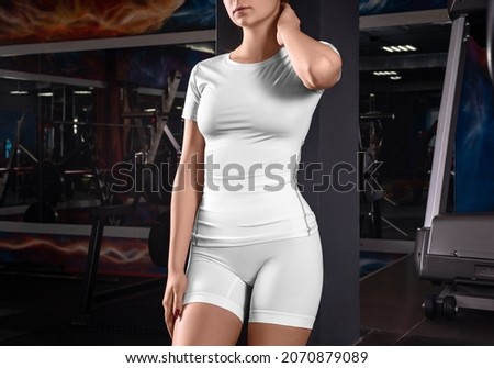 A mockup of white compression underwear for training, a t-shirt, shorts, bicycles on a slender girl, on the background of a gym. Yoga suit template, fitness on the body, blank clothes for design Royalty-Free Stock Photo #2070879089