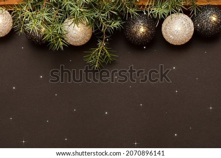 garland in the form of wicker balls on a dark background with a lights and sprig of spruce. Сard. New Year's or Christmas pattern. Place for your text.
