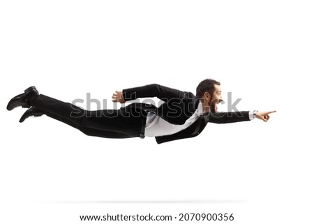 Full length shot of a professional man in a suit and tie flying and pointing isolated on white background Royalty-Free Stock Photo #2070900356