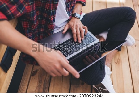 Cropped image of male typing on laptop computer working on online project browsing websites, skilled software programmer communicating in social networks while creating web design via netbook app