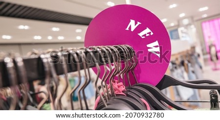 NEW inscription on advertising round banner in fashion clothes store. Concept retail sale fabric and textile business development.