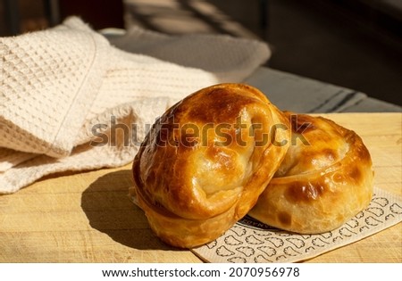 A closeup shot of delicious Argentine ''empanadas'' made by hand on a wood table Royalty-Free Stock Photo #2070956978