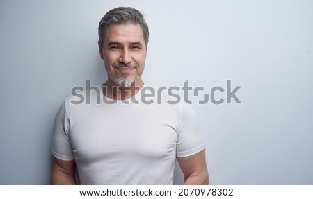 Portrait of mature age, middle age, mid adult casual man in 50s, happy confident smile, standing at wall. White background, copy space. Royalty-Free Stock Photo #2070978302