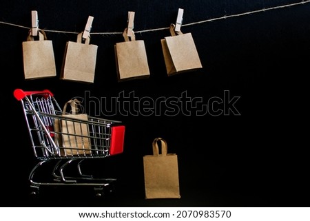 Black Friday Concept. Recyclable Paper Bag In Shopping Cart In Dark Studio Room. The Mockup Header Leaves Room To Add Text Or Design To Promote The Online Business Campaign. Sales