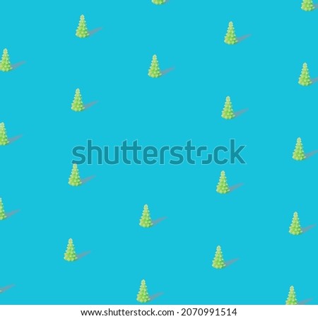 Pattern made with modern surreal shiny green Christmas tree with sunny shadow against blue background. New year party with copy space