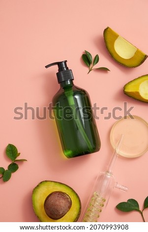 Avocado extract in test tube and petri dish with green leaf , cosmetic jar template for advertising pink pastel background , top view , photography experiment concept