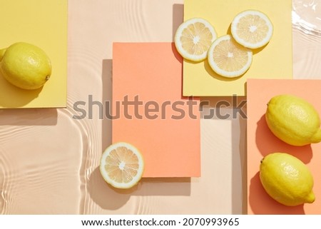 Lemon and sliced lemon in color background with water wave and water drop orange and yellow square podium , top view , blank space for food advertising