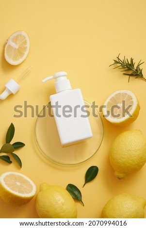 Lemon extract in petri dish and dropper lemon and sliced lemon , green leaf in a yellow background cosmetic template for cosmetic advertising , top view , photography experiment content 