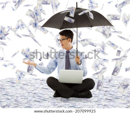 business man holding a umbrella and catching money