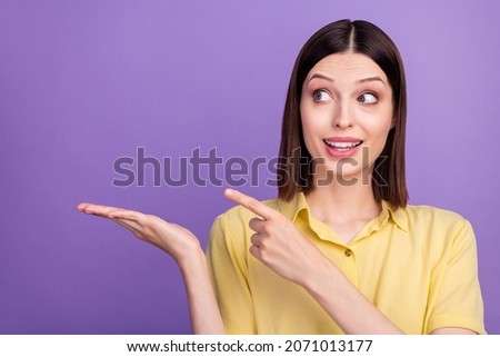 Photo of young pretty lady curious look indicate finger empty space advert choose promotion isolated over violet color background
