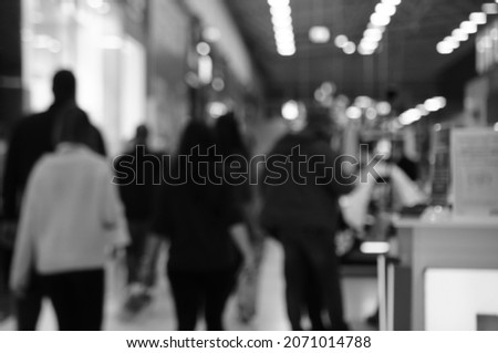 Blurred background. Silhouettes of people in the mall. Black and white photo.