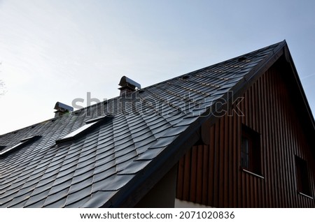gray roof tiles with windows square slate template. square grid pattern. the lower edge of the roof is formed by a metal strip for framing  better tearing off  layer of snow heat transfer through  
