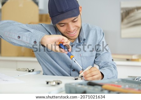 man holding a screw driver tool Royalty-Free Stock Photo #2071021634