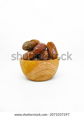 Fresh and healty premium honey tunisia dates (kurma tunisia) in a wooden bowl isolated on white background Royalty-Free Stock Photo #2071037297