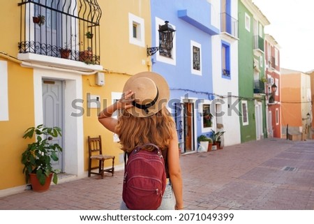 Holidays in Europe. Happy tourist girl visiting the colorful Spanish village Villajoyosa, Alicante, Spain. Royalty-Free Stock Photo #2071049399