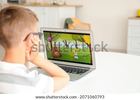 Cute boy watching cartoons at home