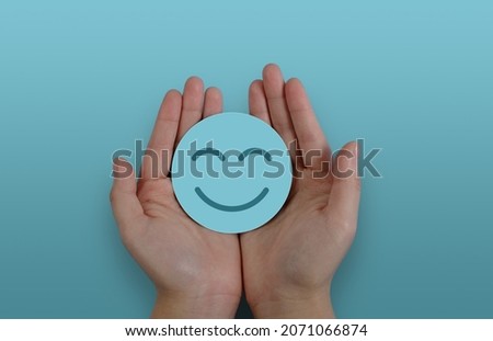 Hand holding paper cut smile face, positive thinking, mental health assessment , world mental health day concept Royalty-Free Stock Photo #2071066874
