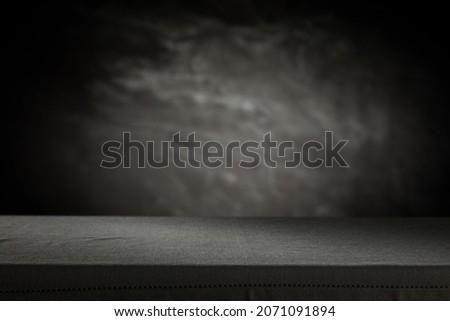 Black wall background with shadows and desk of free space for your product. 