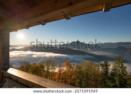 Autumnal sunrise over the mountains and peaks of Salzkammergut with a sea of fog sweeping through the valley from Kulmspitze on lake Mondsee, Upper Austria, Austria