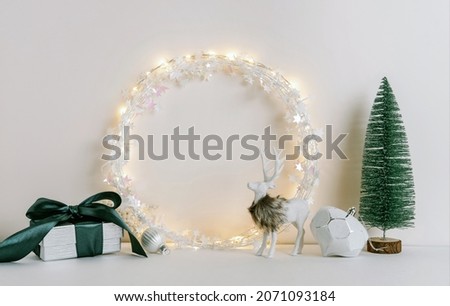 Christmas composition with fir tree branch, wreath, deer and silver stars on white background. Winter festive concept. Template